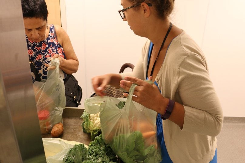 un voluntario que entrega una bolsa de comida a un paciente