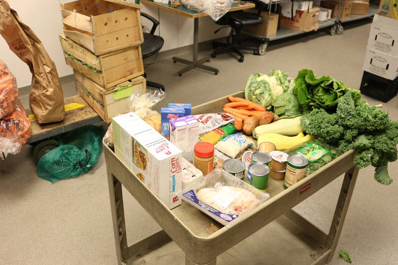 a cart carrying fresh produce and canned goods