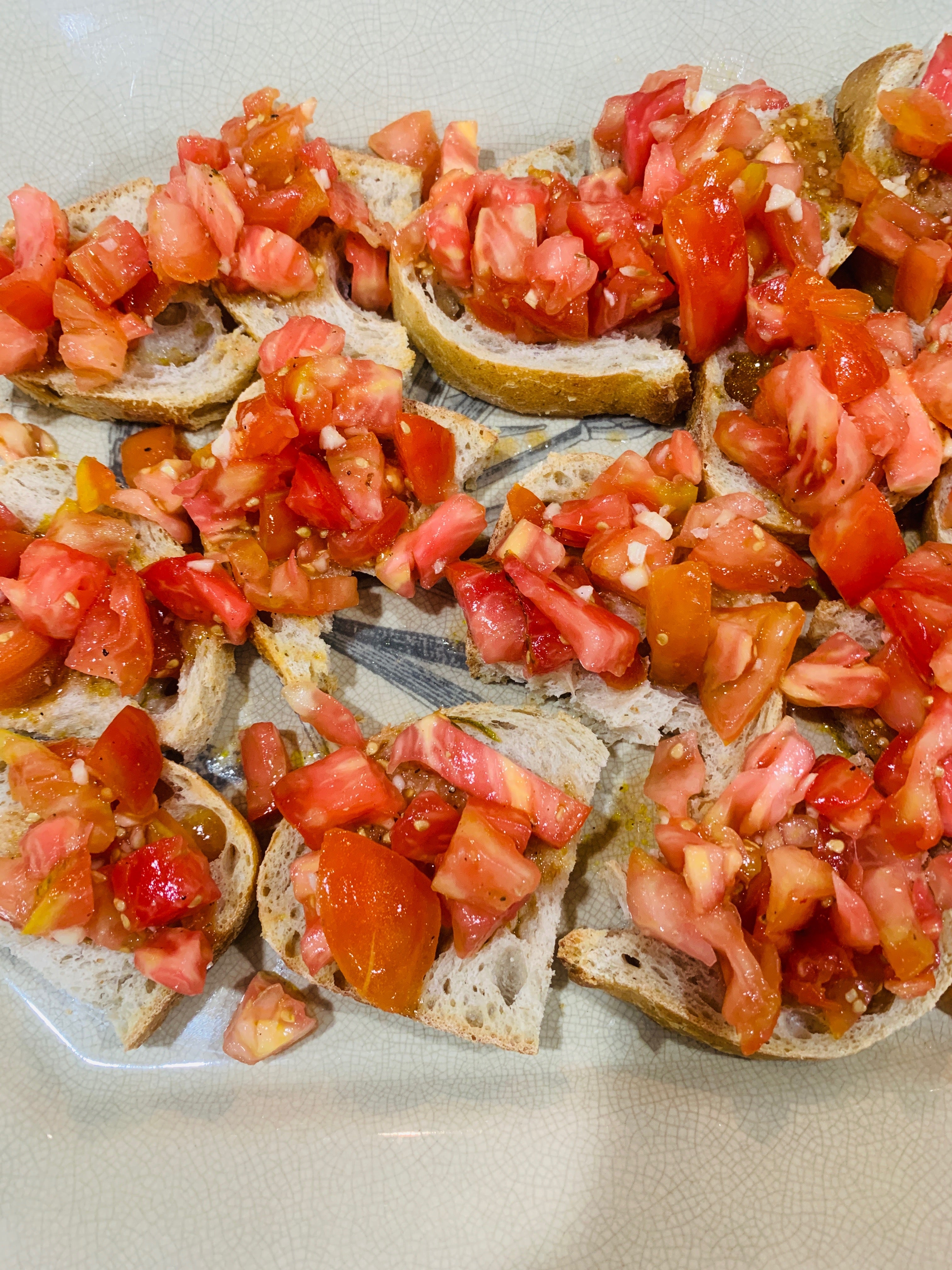 Rodajas de baquette cubiertas con tomates picados, aceite de oliva y ajo