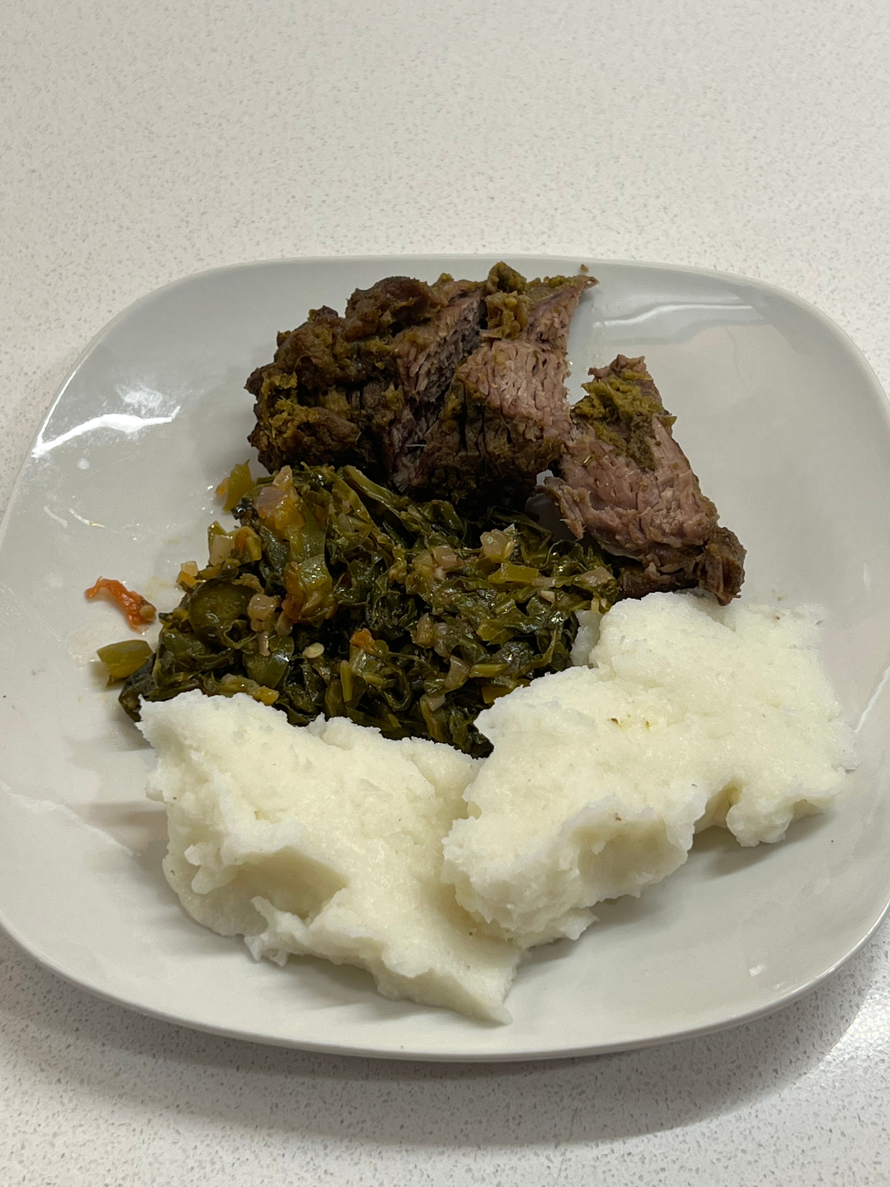 Un plato de ugali, sukuma wiki y nyama choma.