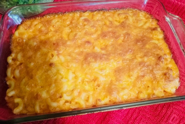 Baking dish filled with elbow macaroni covered in orange cheese