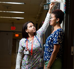 Family medicine doctor is measuring her patient's height.