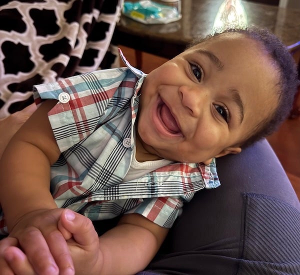 Baby Alessandro at 13 months, clasping his hands and laughing