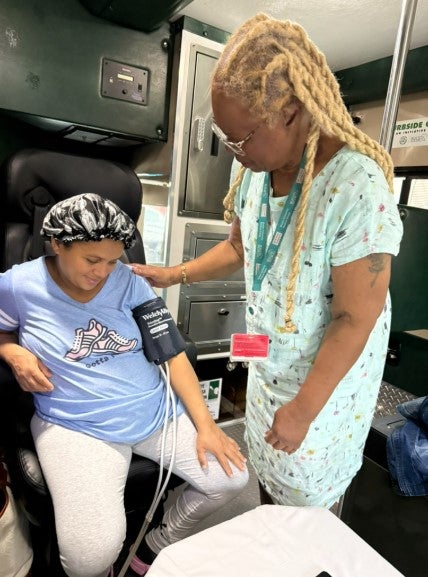 woman getting her blood pressure taken by a nurse