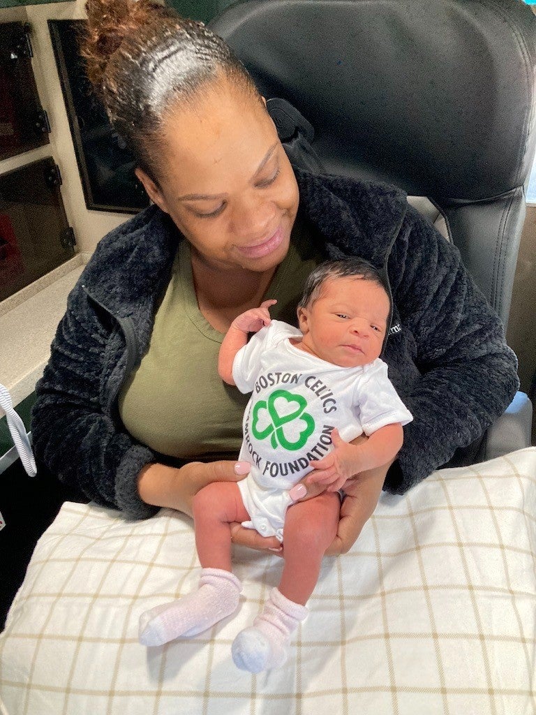 woman in green shirt holding newborn