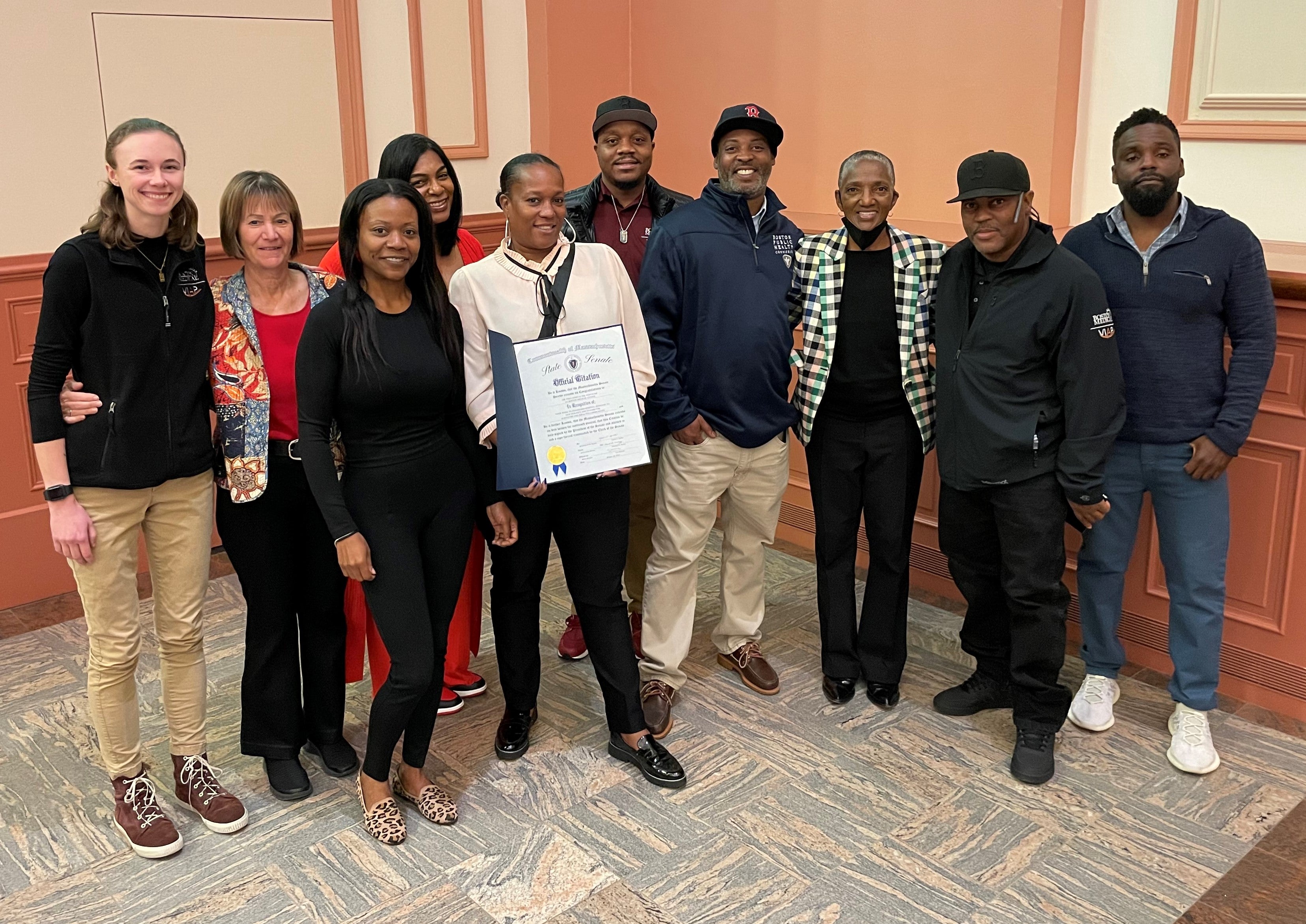 The VIAP Team poses at the MA Coalition to Prevent Gun Violence's Peace MVP Award ceremony, at the Cathedral Church of St. Paul, holding an Official Citation from the State Senate.