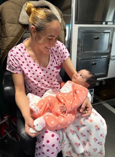 woman in pajamas holding newborn