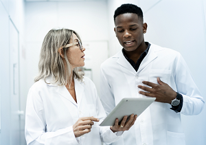 man and woman in hallway looking at ipad