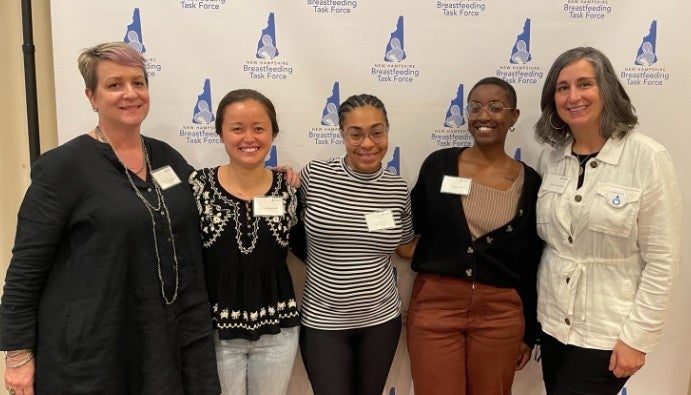 group of women in front of banner
