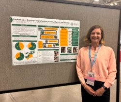 woman in pink sweater with research poster
