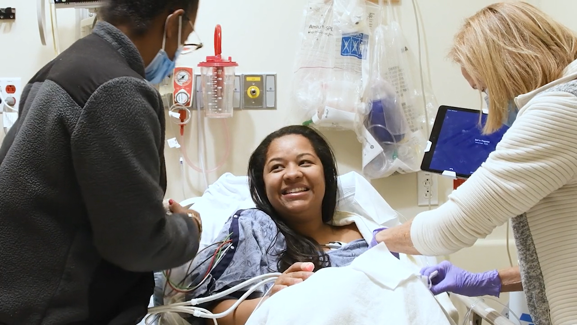 A happy patient at BMC being treated by two nurses