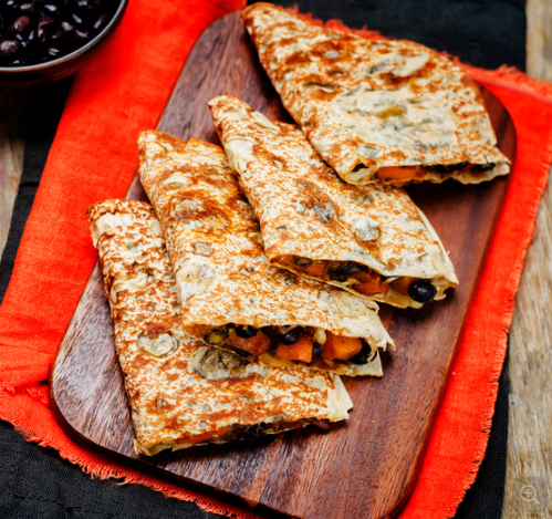 Black bean and vegetable quesadillas sliced and lined up on a plate