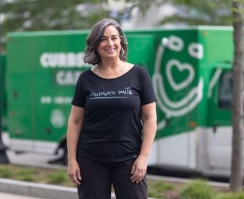 woman in black shirt standing in front of curbside care van